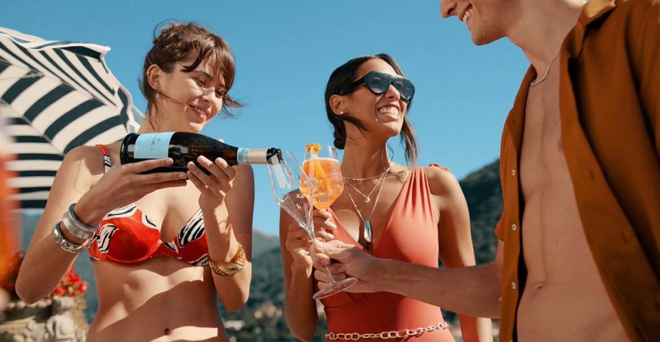 3 Adults enjoying Lamarca Prosecco D.O.C - Woman pouring into glass