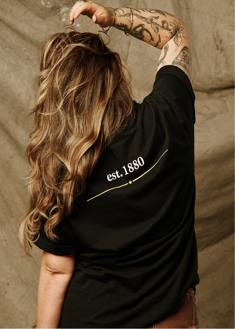 Woman facing back wearing Tee with est. 1880 graphic